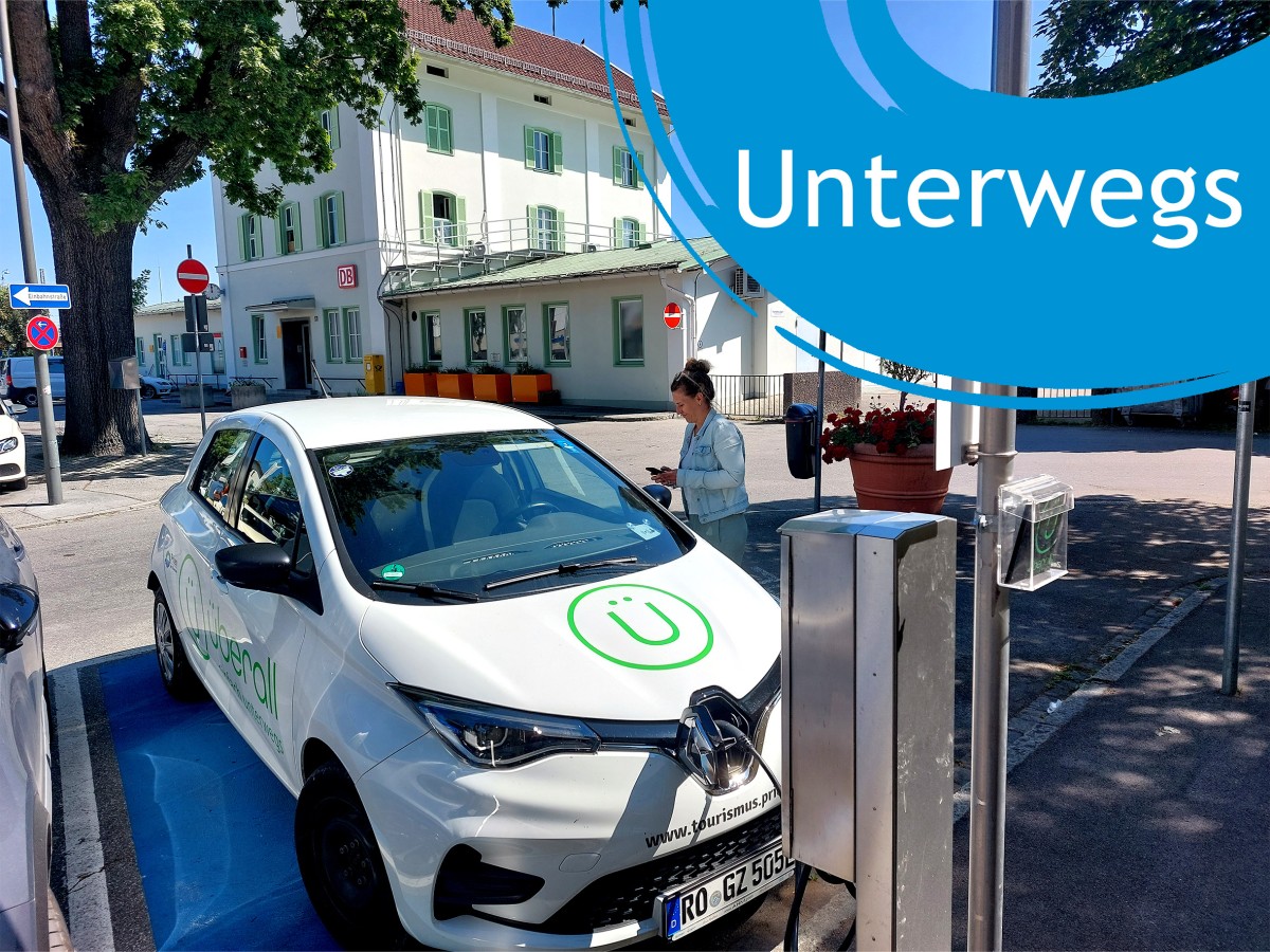 Frau öffnet Carsharing-Auto an einem Bahnhofsparkplatz