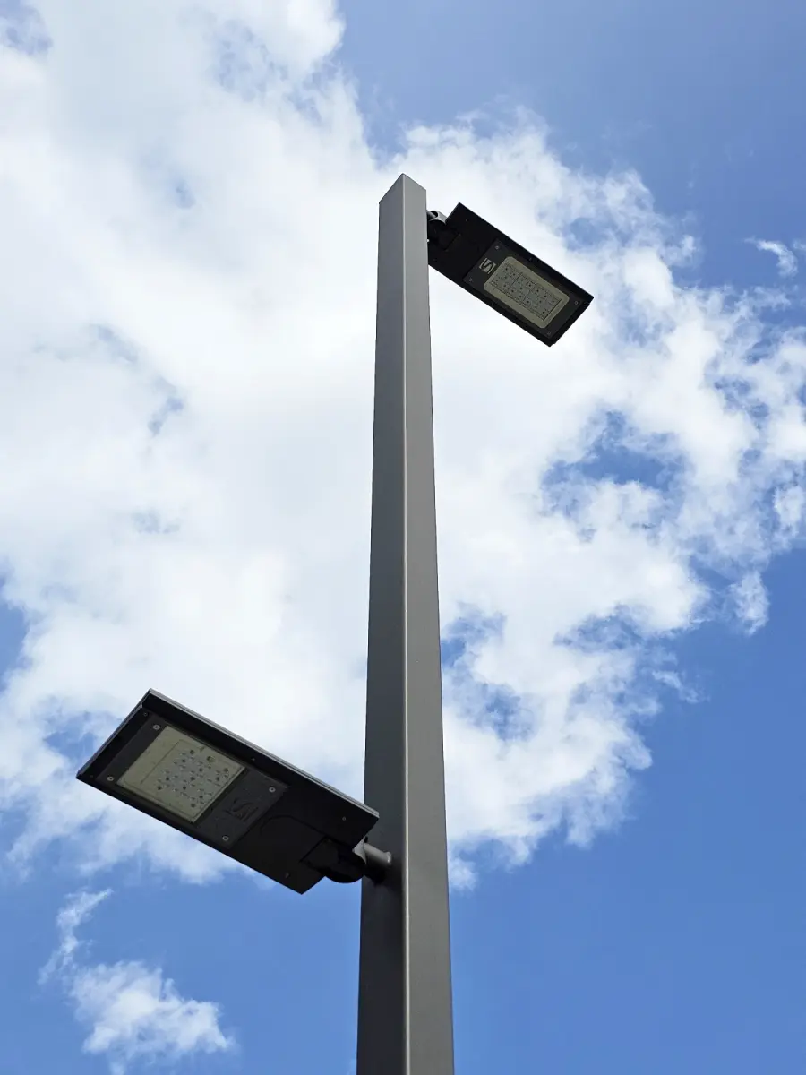 Straßenlampe. Im Hintergrund blauer Himmel mit einer Wolke.