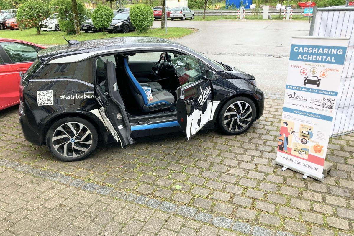 Carsharing Auto schwarz mit offener Tür.