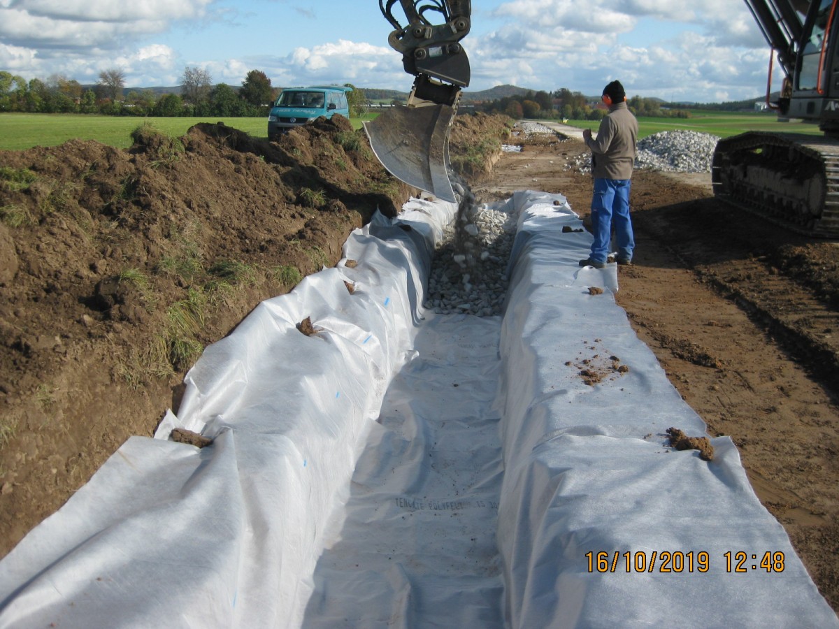 Für die Rigole wurde Vlies in die Wegseitengräben verlegt und mit Kies aufgefüllt