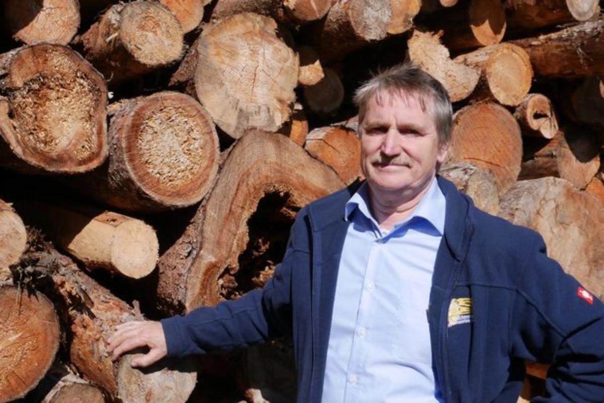 Wolfgang Degelmann vor Holzstapel