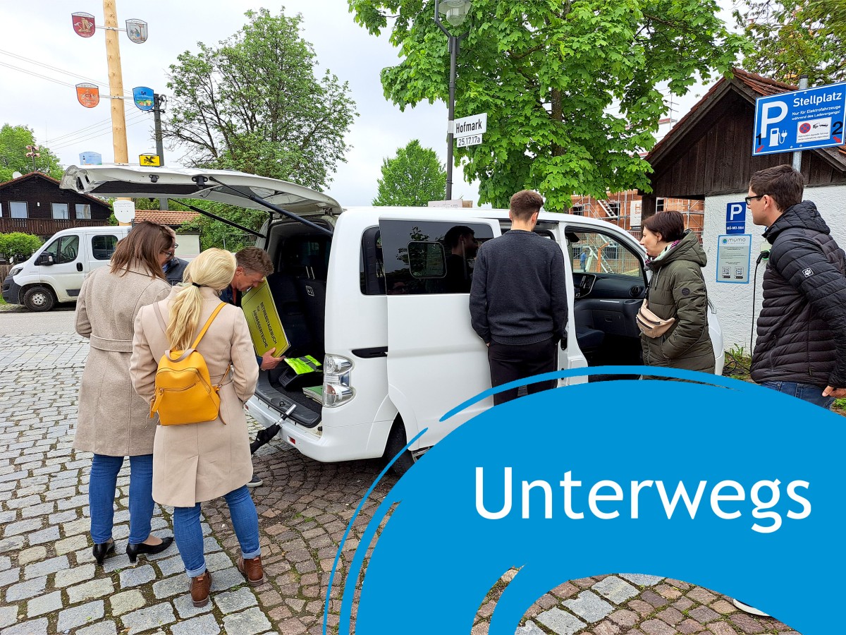 Teilnehmende einer Exkursion sehen sich einen Sharing-Bus an, daneben der Schriftzug "Unterwegs"