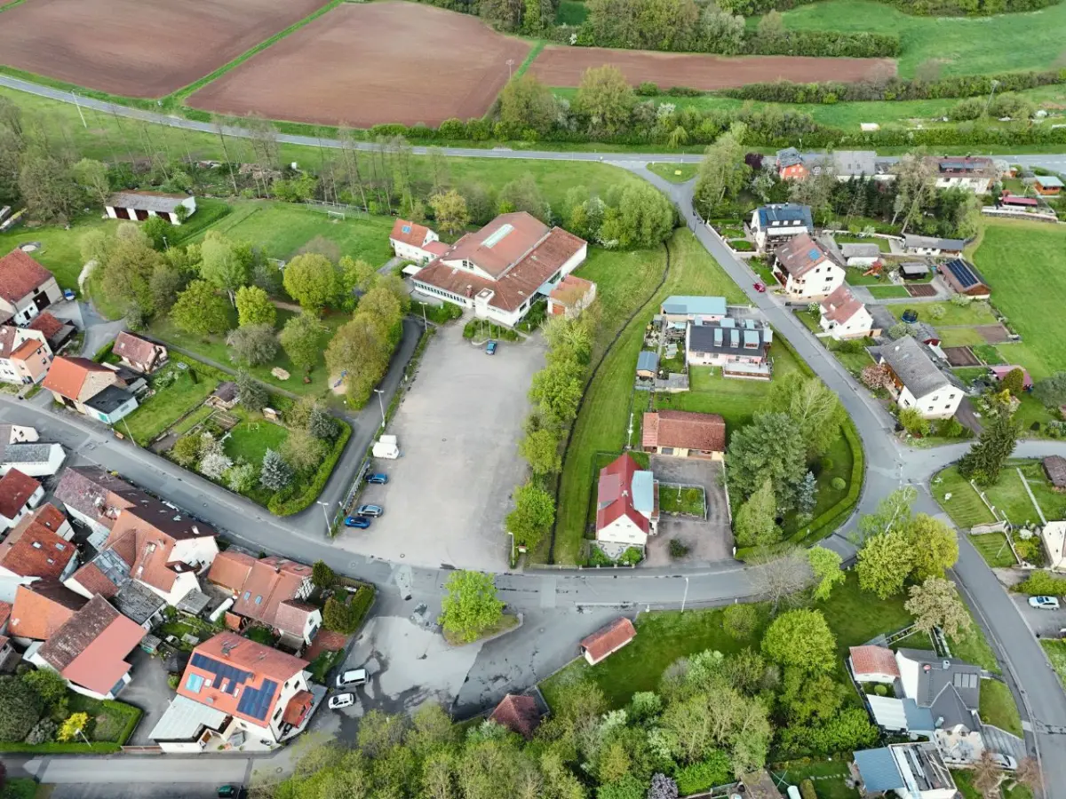 Vogelperspektive des Dorfes Gerach. Im Zentrum ist der gepflasterte Parkplatz.