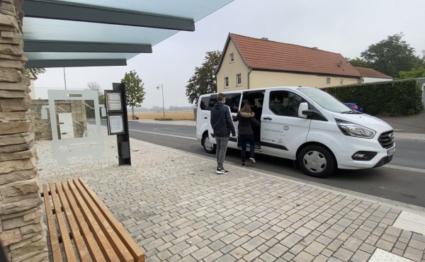 Zwei Auszubildende steigen in den AzubiShuttle-Bus ein