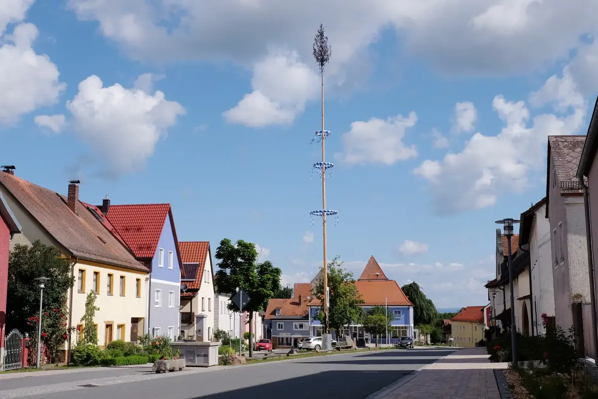 Dorfplatz der Gemeinde Kohlberg. In der Mitte ein Maibaum.