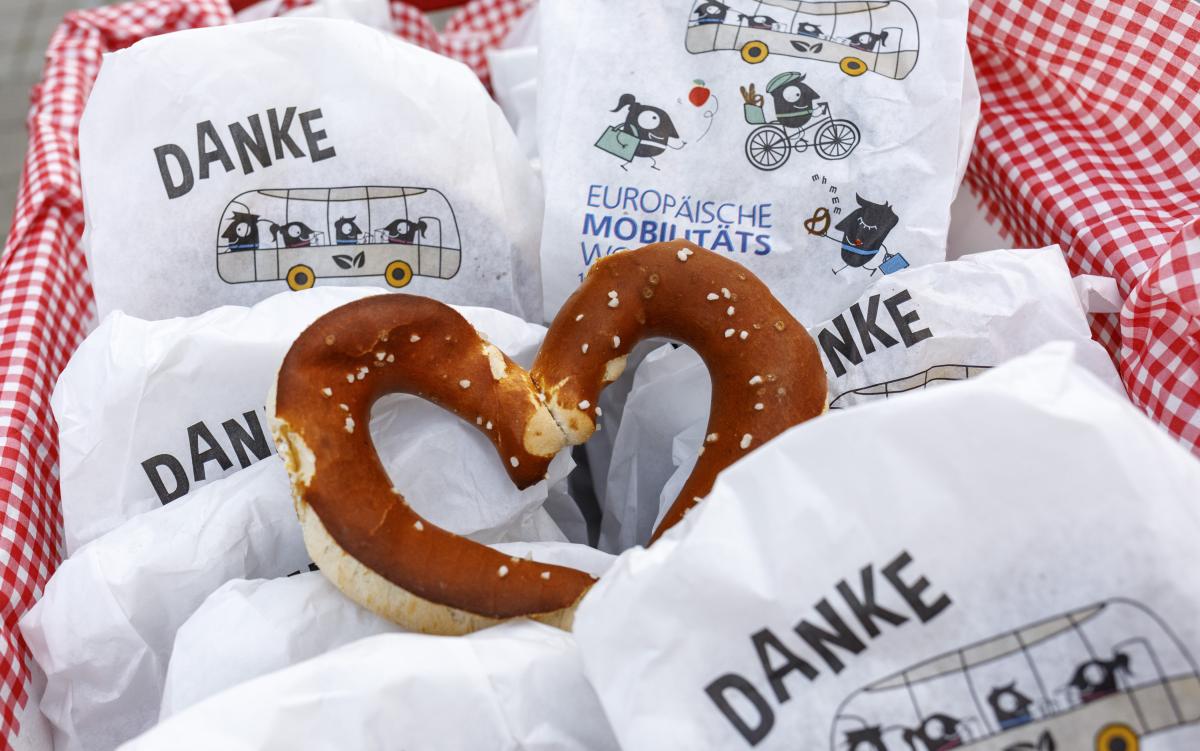 Breze in Herzform zwischen Brotzeittüten im Design der europäischen Mobilitätswoche.