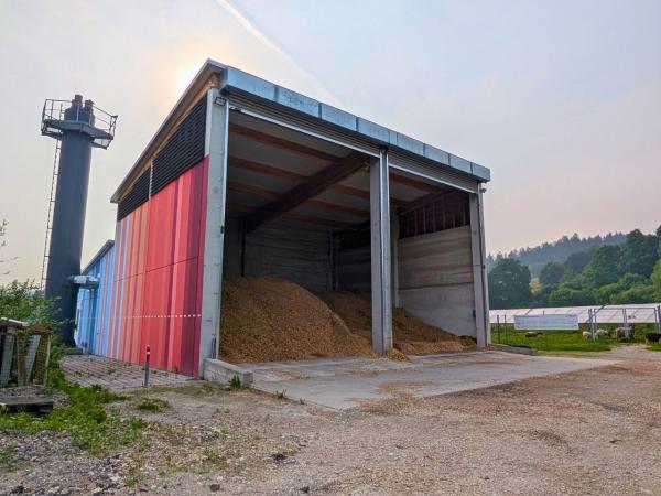 Einlagerung der Hackschnitzel | © Jana Schlesinger Trockene Lagerung von Hackschnitzeln. Rechts PV-Freiflächenanlage.