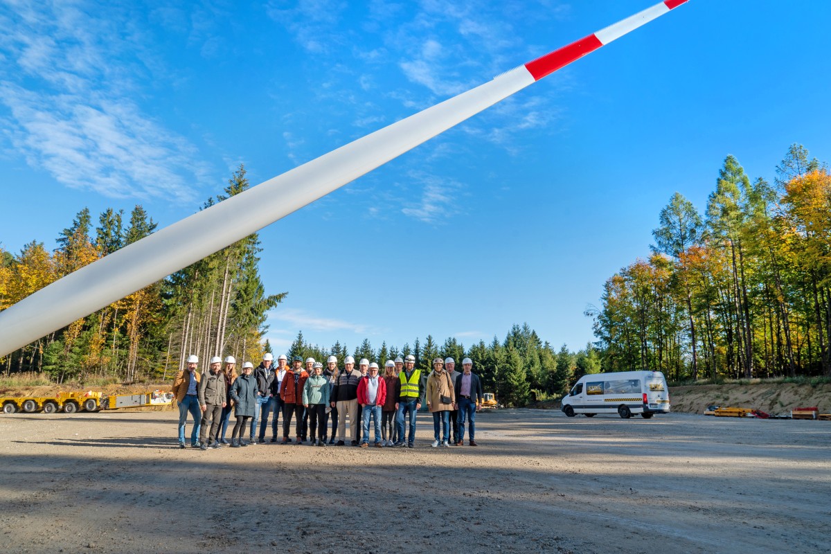 Gruppenfoto vor dem Rotorblatt einer Windkraftanlage