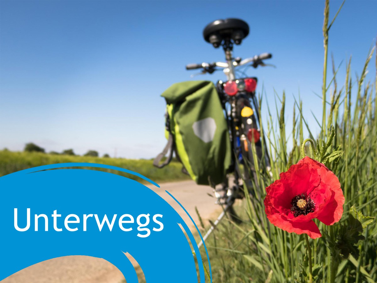 Fahrrad auf einem Feldweg, daneben der Schriftzug "Unterwegs"