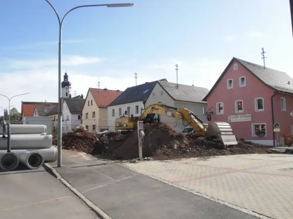 Entsieglung des Dorfplatzes mit einem Bagger.