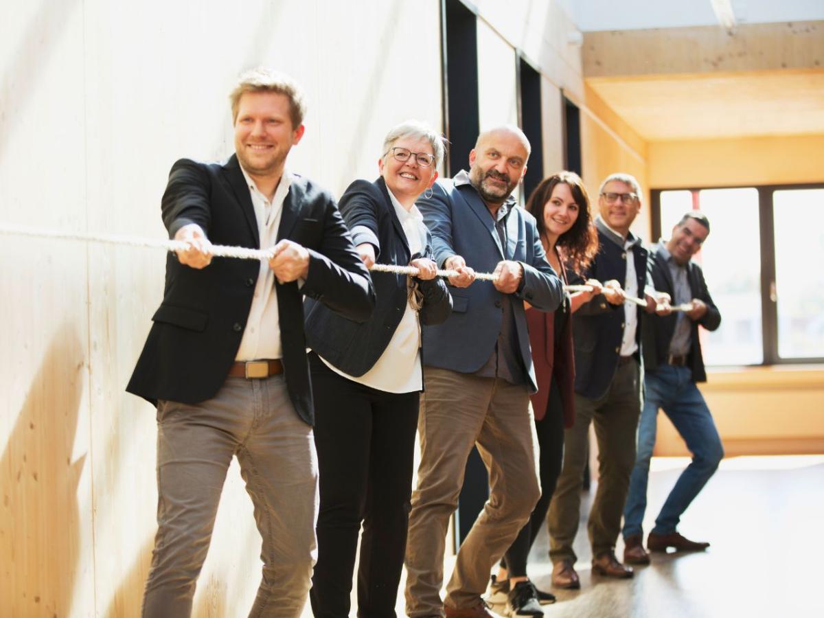 Sechs Personen ziehen gemeinsam an einem Strang.