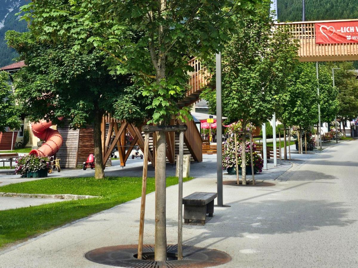 Bäume in Baumrigolen entlang einer Straße.