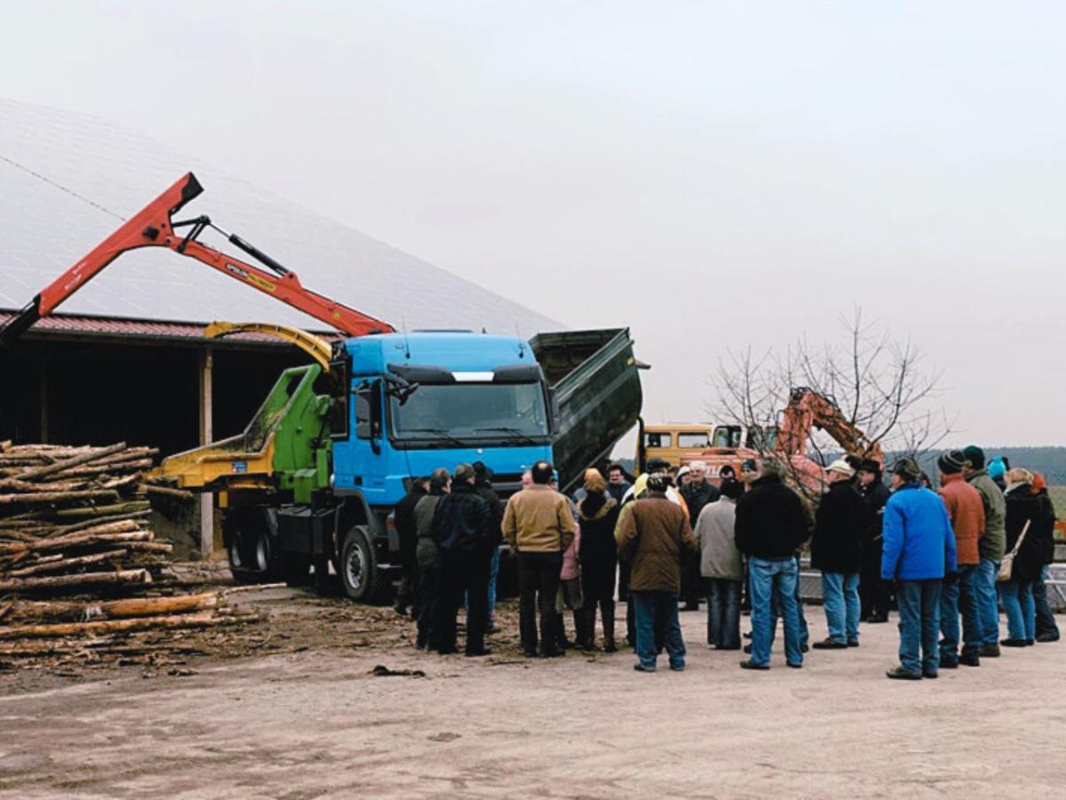 Bürger vor einer Hackschnitzelanlage