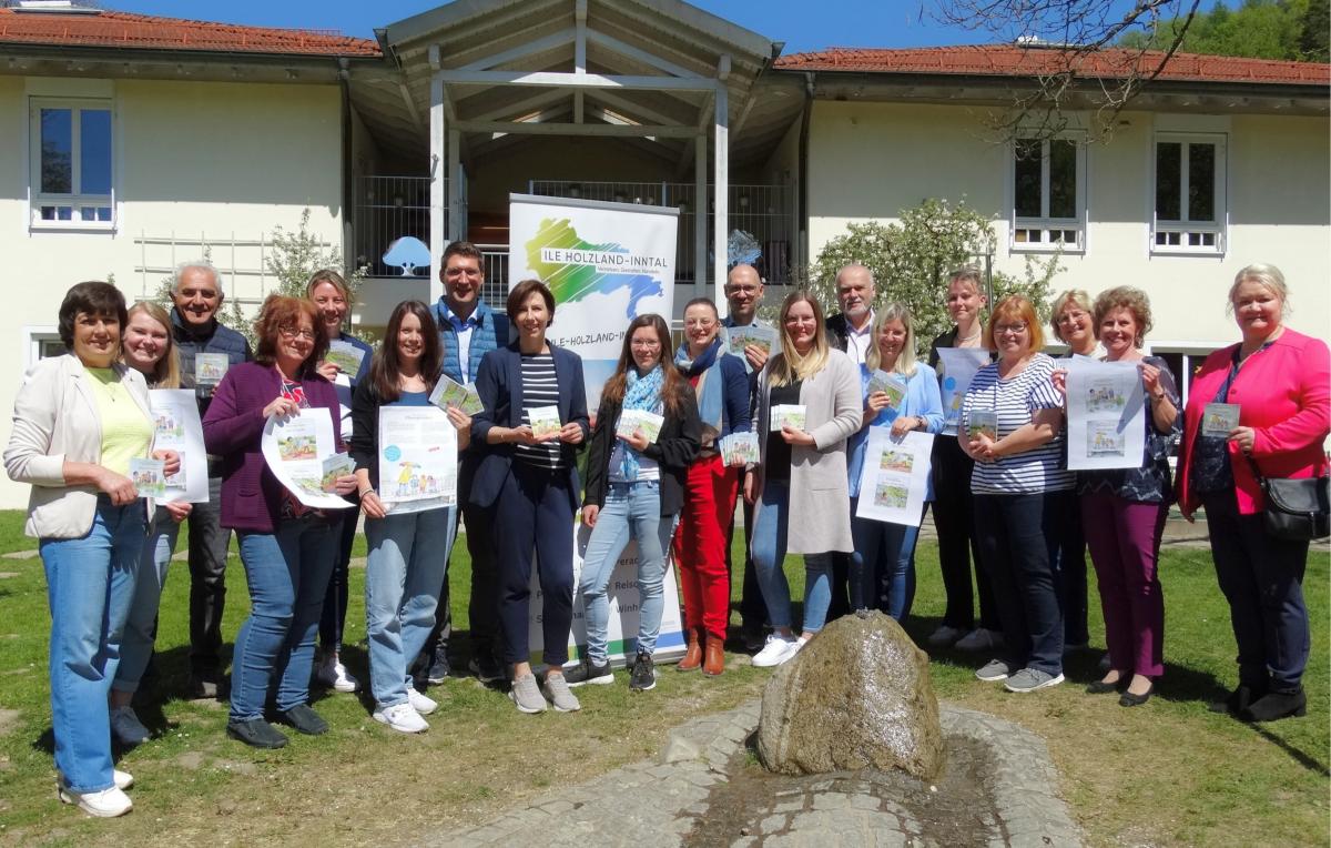 Personen vor einem Haus und halten Pixibücher in der Hand.