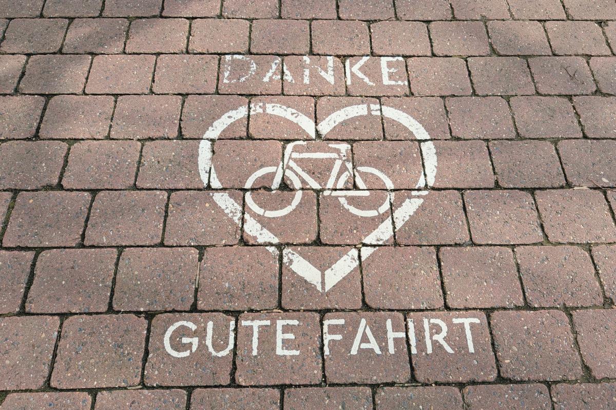 Auf Pflastersteine gesprüht: Danke gute Fahrt - Fahrrad ist in einem Herz.