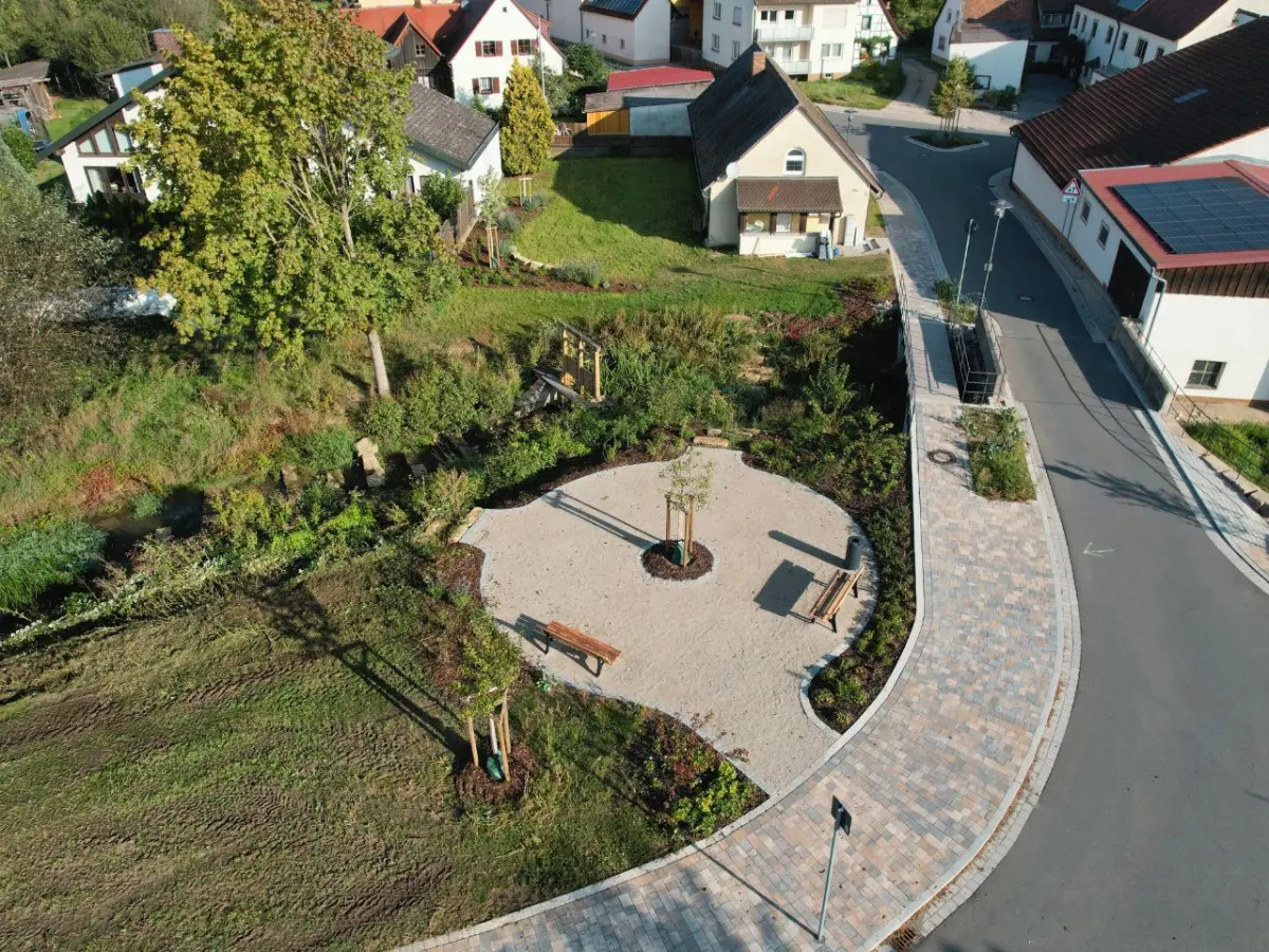 Rondell – Sitzgelegenheiten am Bach mit Blick auf das historische Wehr