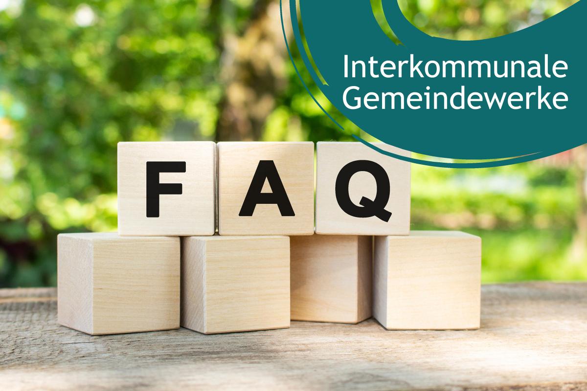 Im Vordergrund sieben Holzwürfel, auf den oberen 3 stehen die Buchstaben FAQ. Hintergrund unscharfe Bäume. Rechte obere Ecke: Blauer Farbbanner mit dem Schriftzug "interkommunale Gemeindewerke"